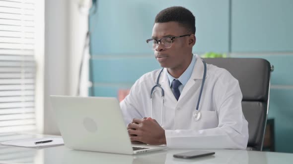 Young African Doctor Talking on Video Call on Laptop in Office