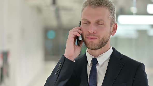 Portrait of Cheerful Young Businessman Talking on Smartphone