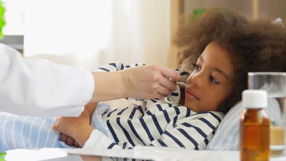 Doctor Measuring Sick Girl's Temperature