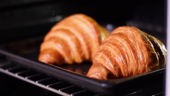 Fresh croissants are taken out of the oven