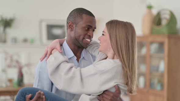 African Man Holding Caucasian Woman in Arms and Swirling Home
