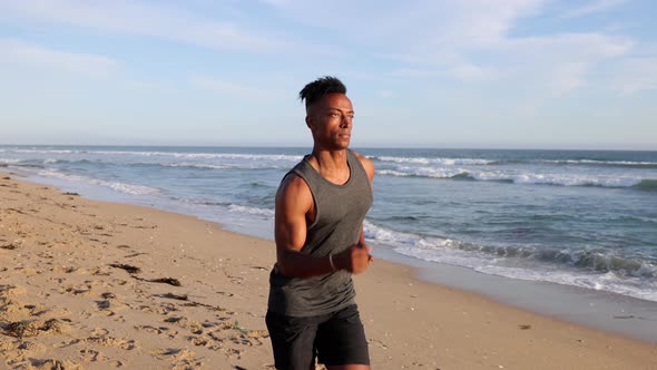 African American Man Jogging At The Beach