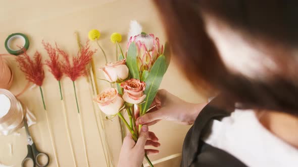 Young Florist Making Bouquet of Roses at Workplace