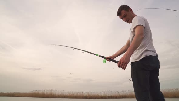 View From the Bottom Up on a Man with a Fishing Rod in His Hands