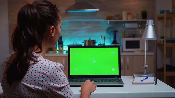 Woman Looking at Laptop with Green Mockup