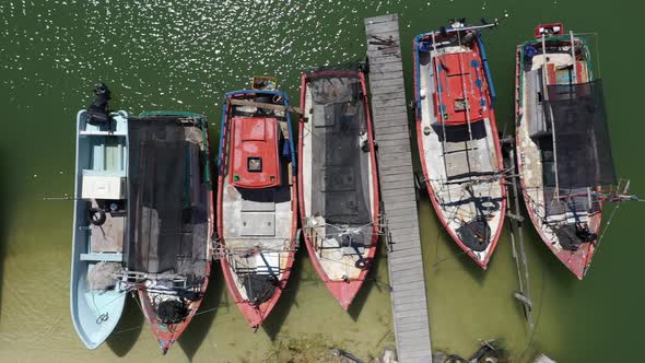Aerial view looking straight down and camera sliding to the left showing small wooden fishing boats