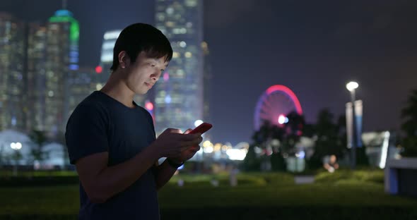 Man use of mobile phone in city at night