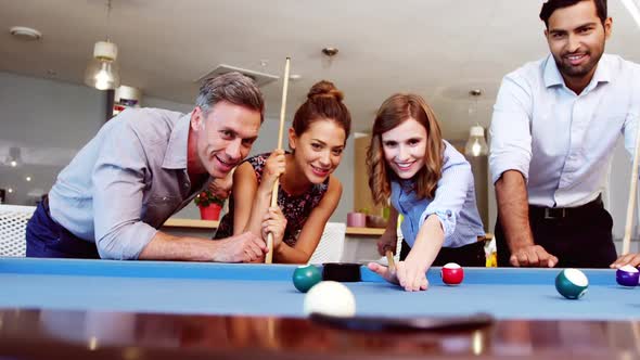 Executives playing pool in office