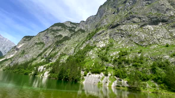 Tilt down shot of peaceful mountain landscape and clear natural Lake during sunny day with blue sky