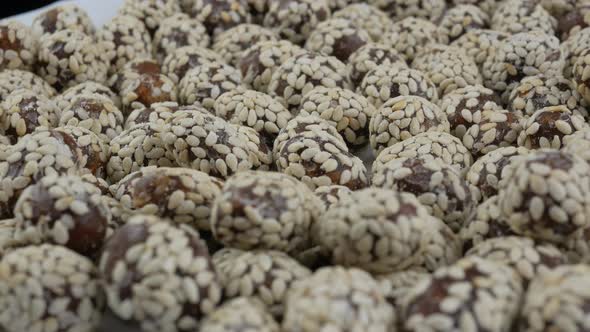 Heap of chocolate balls candies in sugar glaze. Candy peanuts with sesame seeds