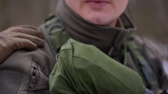 Closeup Hand Tapping Shoulder of Unrecognizable Soldier Taking Cover Outdoors