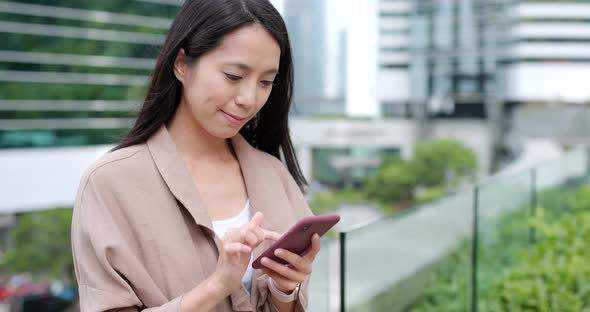 Asian woman sending sms on mobile phone