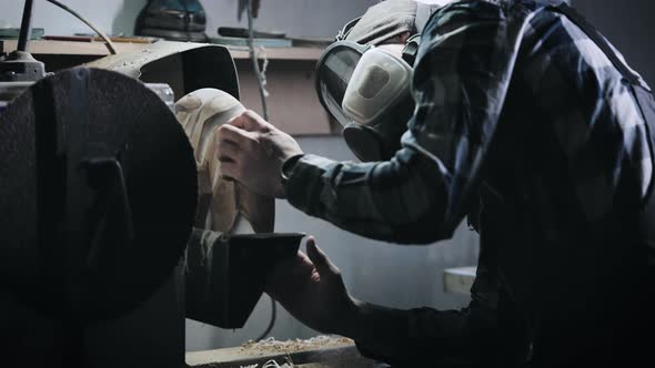 A Man in a Respirator Works on a Lathe in a Carpentry Workshop