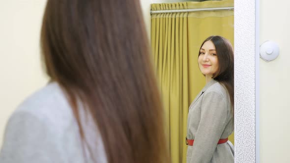 Young Woman Brunette Poses Looking at Costume in Mirror