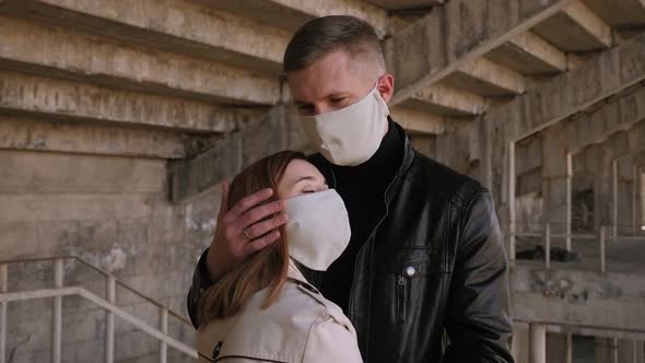 Portrait of a Young Couple in Love in Protective Medical Masks in the City