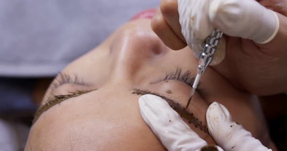 Young woman gets facial beauty procedure, microblading procedure on woman eye at beauty salon