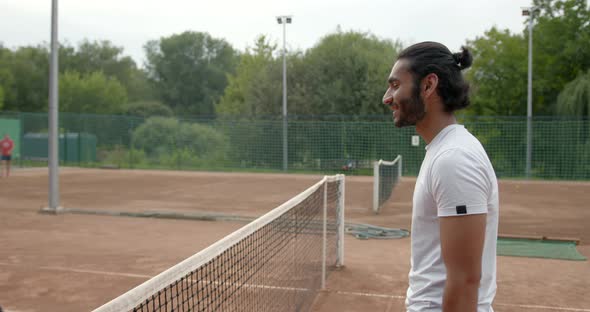 Pakistani Man and Black Woman Handshaking at Tennis Court