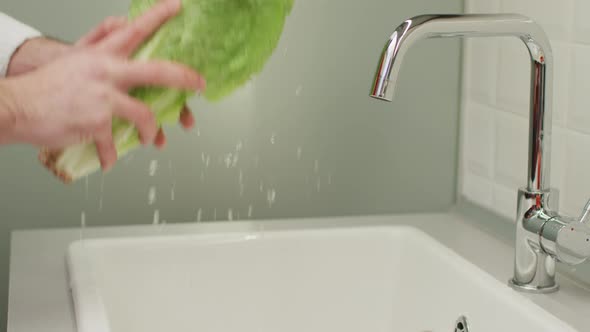 One person washing lettuce