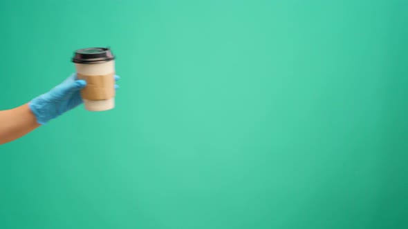 People's Hand Passing One Another Coffee to Go Coffee Delivery Against Mint Background