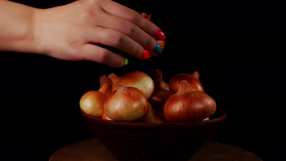 Pile of Whole Bulbs of Onion in Ceramic Bowl on Table