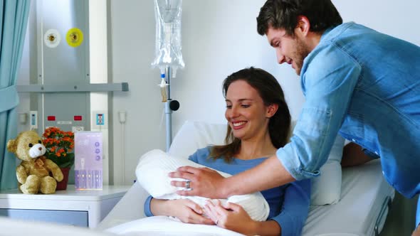 Couple with their newborn baby in ward