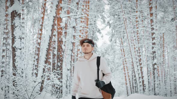 a Tourist in a Beautiful Winter Forest Goes on Camera