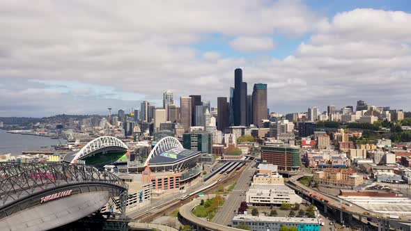 Aerial time lapse of Seattle's stadium district with clouds casting large shadows over the city.