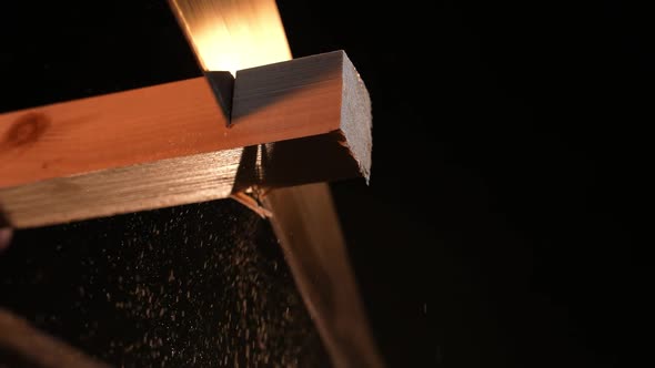 Man Carpenter Saws a Wooden Board with a Hand Saw