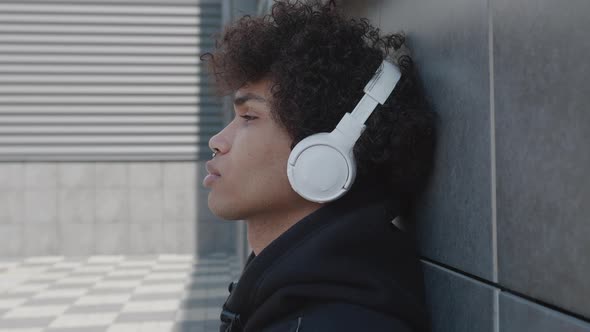 Unhappy Afro American Tourist in Headphones Listening to Music Outdoors Having Fun Alone in the