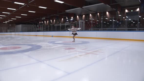 Ice Skater In Sweater Performing On Ice Rink