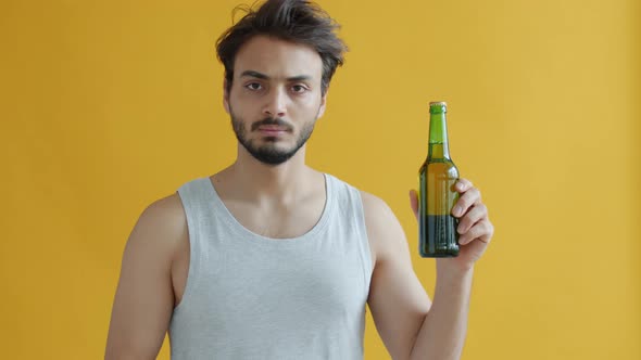 Young Arab Sportsman Looking at Beer Bottle Then Saying No Avoiding Alcohol