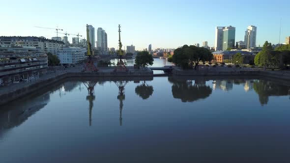 Aerial of the water of Puerto Madero docks reflecting the cityscape at morning