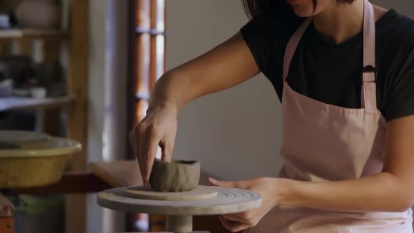 Young female potter working in her studio