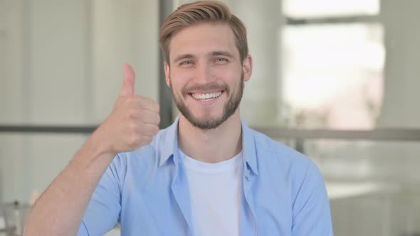 Portrait of Young Creative Man Showing Thumbs Up Sign