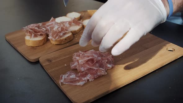 Cook in Gloves Prepares Prosciutto Sandwiches at Food Fest