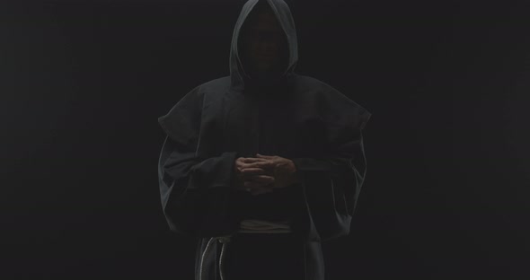 PitchBlack Background of a Monk With Eyes Gazing Straight Into Camera