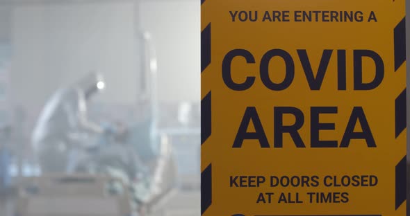 Covid Area Sign Hanging on Glass Door of Quarantine Zone in Hospital