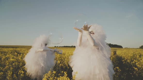 Two Cheerful Clowns Mime in White Suits Snowflakes Blow Bubbles in the Field