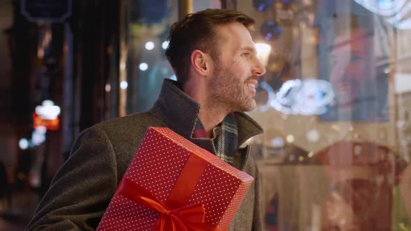 Man with a big gift entering the flower shop