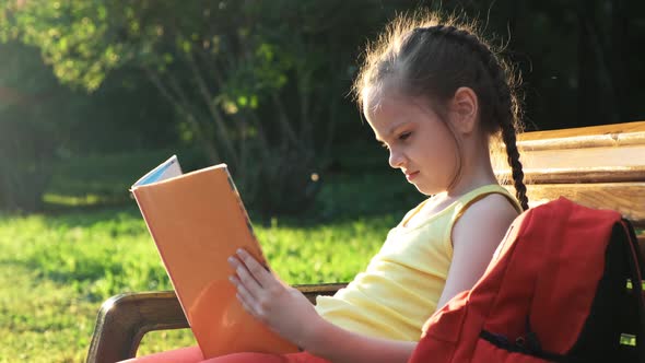 Schooling Concept. A Schoolgirl Is Sitting on a Bench