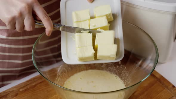 Woman Puts Butter Cubes Into Bowl for Making Gingerbread