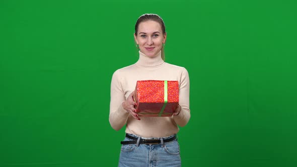 Positive Woman Stretching Wrapped Gift at Camera Smiling at Chromakey Background
