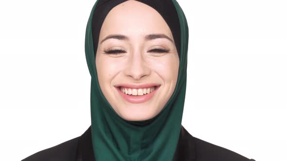Portrait of Positive Arabic Woman in Traditional Hijab Posing Looking on Camera and Laughing Over