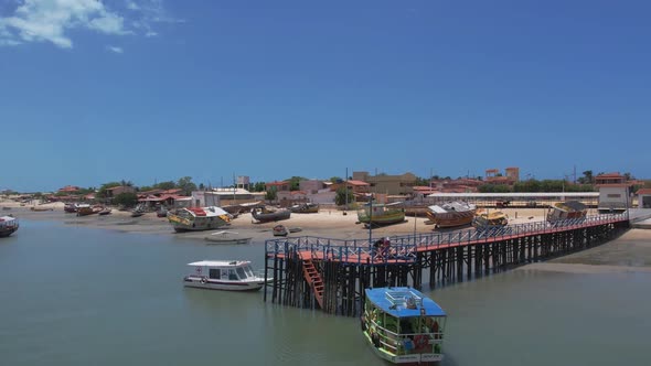 Orbiting Over Wooden Pier With Boats Mooring During Sunny Day In Natal, Brazil. Aerial Drone Shot