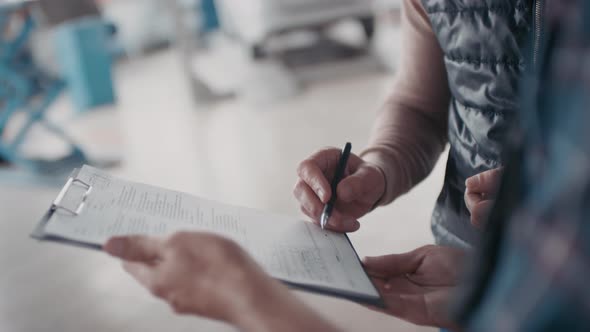 Unrecognizable Man Signing Invoice for Services Rendered