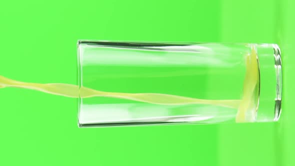 Vertical Video Juice Pouring Into Glass Isolated on Light Green Background