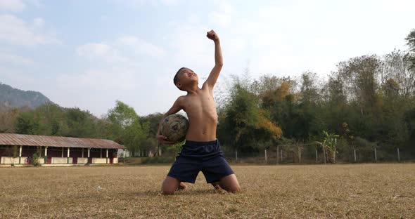 Commitment Of Rural Boy With Old Soccer Ball