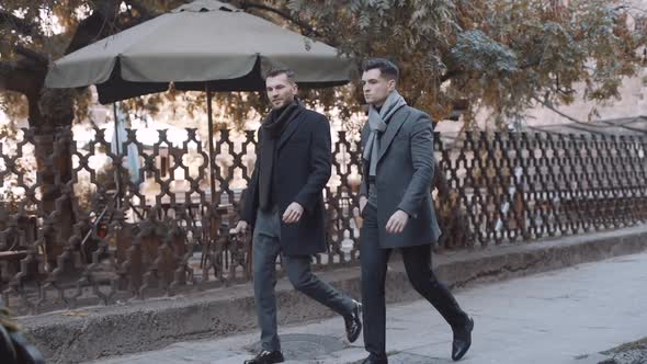 Serious businessmen walking in suits in the city. Slow motion