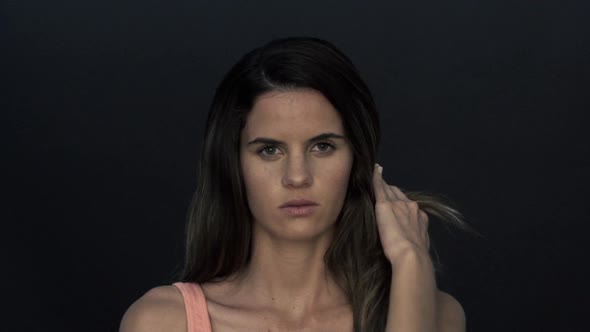 Woman pushing hair back from face, portrait