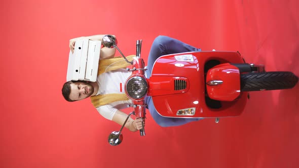 Portrait of a Courier Driving a Moped, Scooter Fast Pizza Delivery, Isolated Red Background